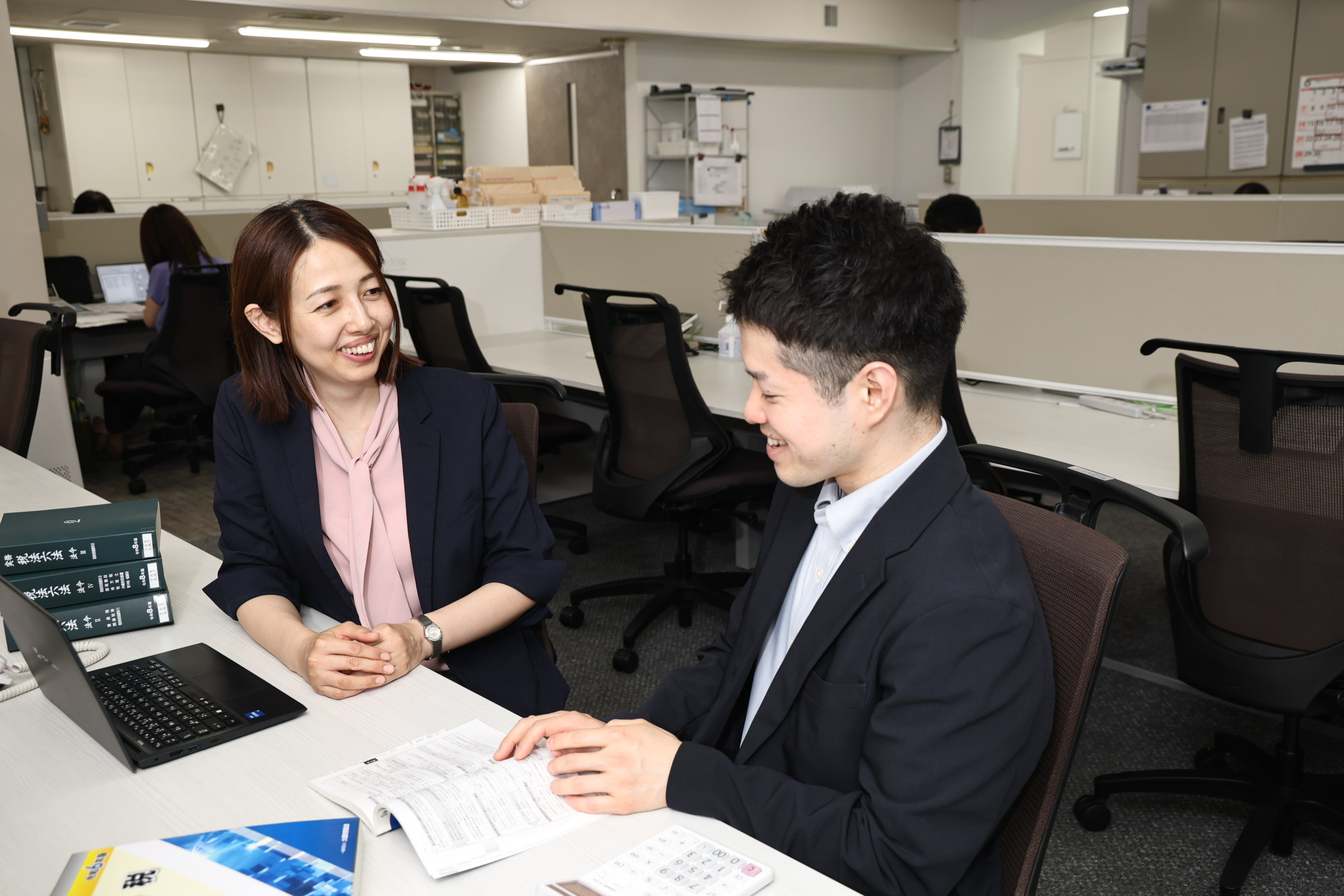 資料を見ながら相談する社員